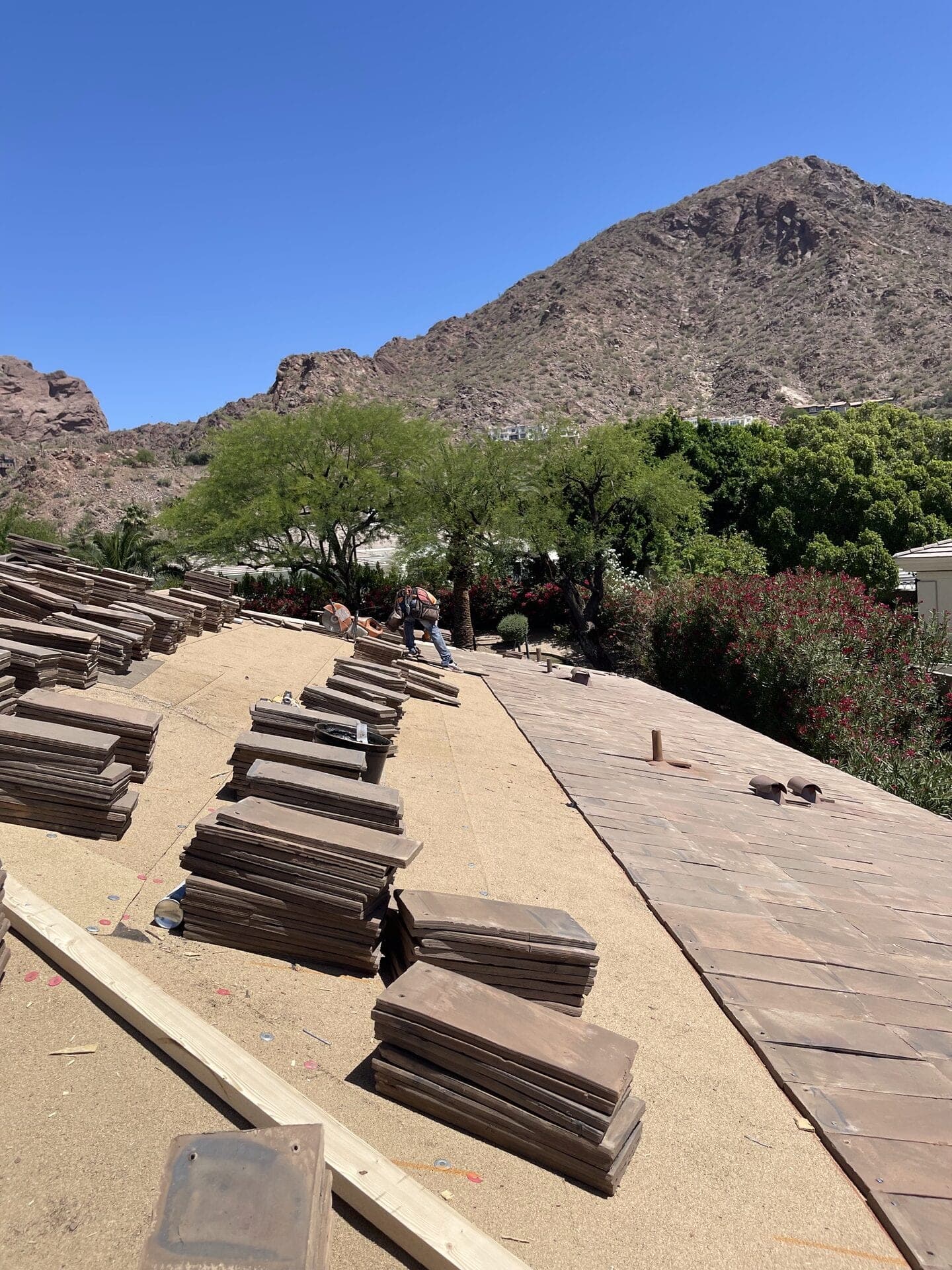 Staged tile and a completed tile section during a roof replacement near Camelback Mountain